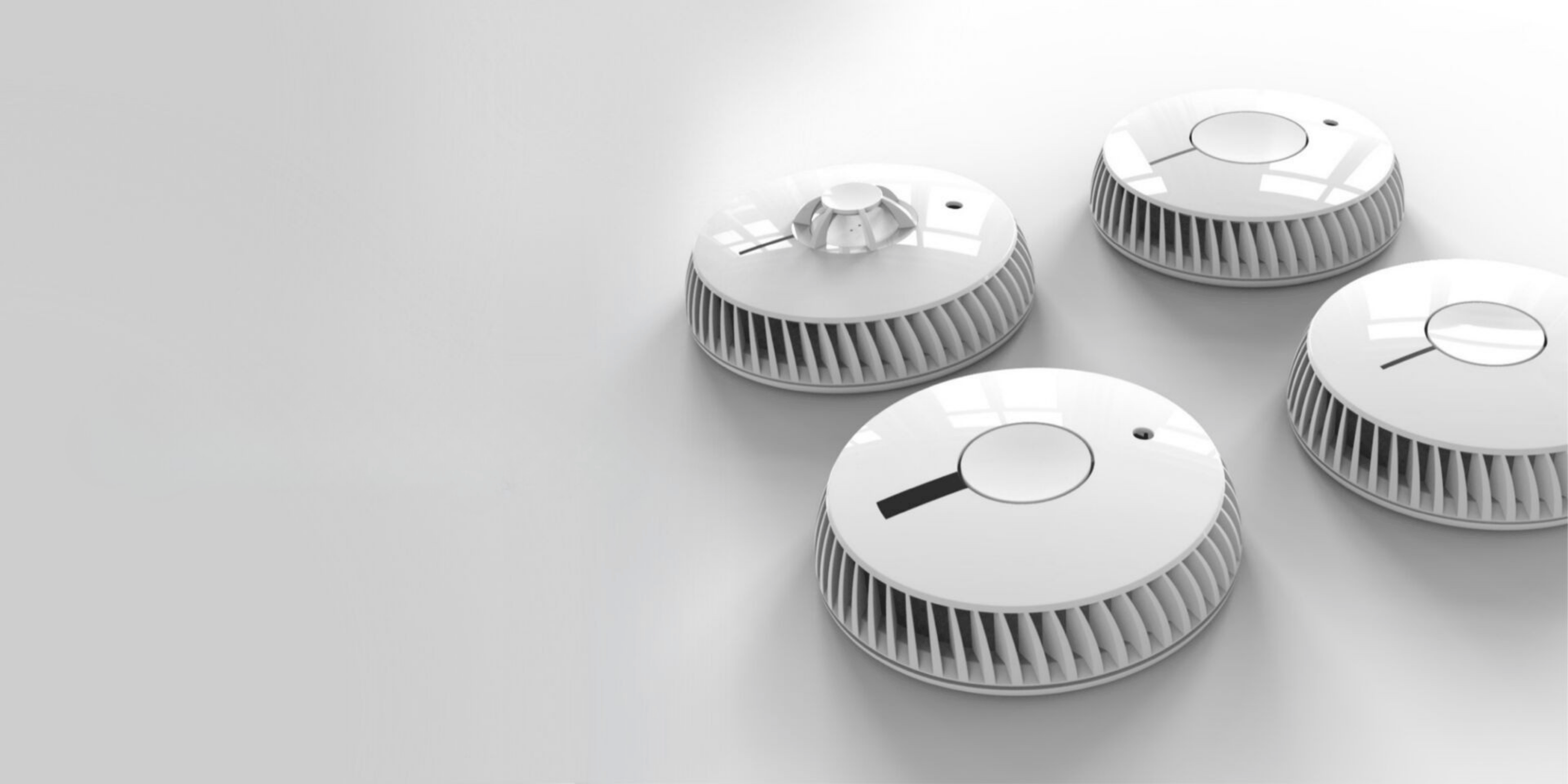 Vier weiße Rauchmelder von FireAngel auf grauem Hintergrund, unterschiedliche Modelle mit Testtaste und Lüftungsschlitzen
